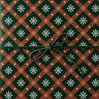 Christmas plaid wrapping paper with white snowflakes and a dark green ribbon bow, perfect for holiday gift wrapping.