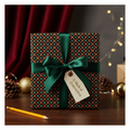 Elegant Christmas wrapping paper with a green satin bow, "A Mark of Distinction" tag, and festive snowflake pattern on a dark background.