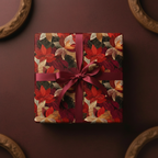 Elegant square gift wrapped in red and gold floral wrapping paper with a burgundy ribbon.