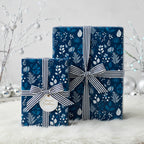 Elegant navy floral wrapping paper with striped ribbon, perfect for Christmas or winter holiday gifts.