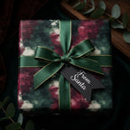 Elegant Christmas gift wrap with green and burgundy pattern, dark green ribbon, and "From Santa" tag.