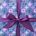 Luxury Christmas gift wrap with a purple satin ribbon and snowflake pattern in shades of blue and lavender.