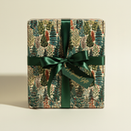 Elegant Christmas gift wrapped in botanical forest wrapping paper with a dark green satin ribbon and gift tag.