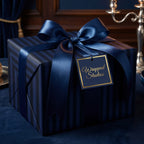 Elegant navy blue striped gift wrapped with satin ribbon bow and gold foil tag, perfect luxury gift wrap.