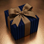 Elegant navy striped wrapping paper with a gold ribbon bow on a gift box.