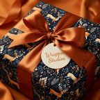 Wrapped Studios dark floral wrapping paper with deer pattern and rust-colored satin ribbon.