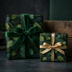 Christmas wrapping paper on two gift boxes with green and gold ribbons on a dark background. Evergreen Colorado Spruce pattern on paper.
