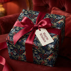 Elegant floral gift wrap with red ribbon and "Warm Wishes" tag.