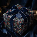Elegant square gift wrapped in floral Christmas wrapping paper with navy velvet ribbon.