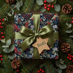 Elegant Christmas gift wrap with a navy floral pattern, olive ribbon, and “Noël” tag.