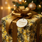 Elegant floral wrapping paper on a gift box with a gold satin ribbon bow for Christmas or holiday.