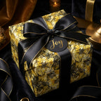 Elegant floral gift wrapped in yellow wrapping paper with black ribbon and "Joy" tag from Wrapped Studios.