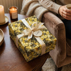 Elegant gift wrapped in yellow floral wrapping paper, tied with a cream ribbon and "Love" tag.