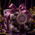 Elegant purple gift box wrapped in floral patterned wrapping paper with matching bow and tag.