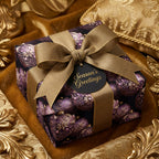 Luxury Christmas gift wrap with purple ornament pattern and gold ribbon, from Wrapped Studios.