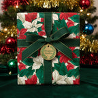 Elegant Christmas gift wrapped in poinsettia floral wrapping paper with green ribbon and bow.