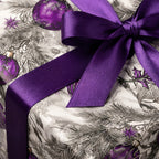 Luxury Christmas gift wrap with purple satin ribbon and ornament pattern.