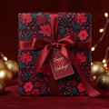 Elegant Christmas gift wrapped in floral wrapping paper with a red ribbon and a tag that says "Happy Holidays!".