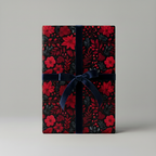Elegant gift box wrapped in red floral Christmas gift wrap with a dark blue velvet ribbon.