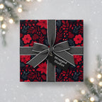 Elegant Christmas gift wrapped in red poinsettia floral paper with a gray ribbon and bow.