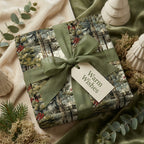 Rustic winter forest Christmas wrapping paper with red berries, a green ribbon & "Warm Wishes" gift tag.