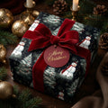 Christmas gift wrapped in snowman print paper with a red velvet bow and matching tag.