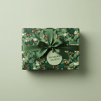 Dark green Christmas gift wrap with winter floral pattern and matching satin ribbon bow.