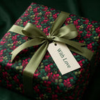 Elegant gift wrapped in floral wrapping paper with sage ribbon and "With Love" tag.