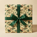 Vintage-style Christmas gift wrap with holly berries and a dark green satin bow.