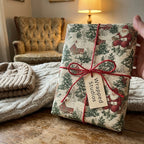 Wrapped Studios Christmas gift wrap. Vintage Santa and winter scene tied with red twine.