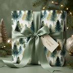 Elegant Christmas gift wrap with watercolor forest design and sage green ribbon.