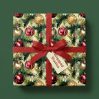 Square gift wrapped in Christmas ornament wrapping paper with a red ribbon and bow.