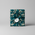 Elegant gift box wrapped in teal floral wrapping paper with a satin teal ribbon.