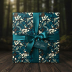 Elegant gift wrapped in navy blue floral wrapping paper, accented with a teal satin ribbon and "For You" tag.