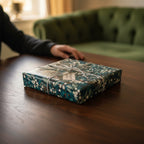 Elegant gift wrapped in dark teal floral wrapping paper with twine and a gift tag.