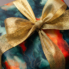 Elegant gift wrapped in watercolor-style paper with gold ribbon; Luxury gift wrap from Wrapped Studios.