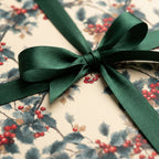 Holiday gift wrapped in floral Christmas wrapping paper with dark green satin ribbon.