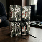 Geeky floral circuit board wrapping paper on a gift box with a black bow by Wrapped Studios.