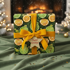 Citrus-themed Christmas gift wrap with an orange ribbon and a "Happy Holidays" tag.