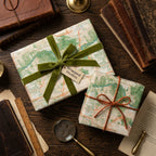 Vintage map wrapping paper on gifts with green velvet ribbon and rustic twine by Wrapped Studios.