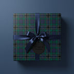 Square gift wrapped in green plaid paper with a navy ribbon and bow.