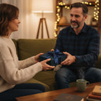 Couple exchanging a gift wrapped in blue & green plaid Christmas wrapping paper with a satin bow.