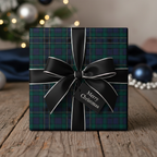 Square gift wrapped in tartan Christmas wrapping paper with black ribbon on wooden table.