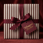 Elegant striped wrapping paper with burgundy ribbon and bow, perfect luxury gift wrap for any occasion.