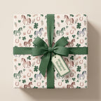 Horse wrapping paper with shamrocks and green ribbon on a gift box, cute birthday gift wrap by Wrapped Studios.