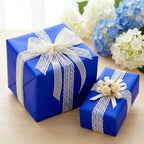 Elegant royal blue gift boxes wrapped with lace ribbon for birthdays or special occasions.