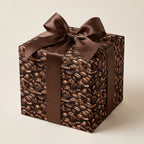 Coffee lover's gift: Square gift box wrapped in coffee bean print paper with a chocolate-brown satin ribbon.
