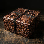 Square gift box in coffee bean wrapping paper with black string and "Hand Roasted" tag.