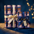 Two gifts wrapped in birthday wrapping paper featuring cake illustrations and tied with satin ribbons.