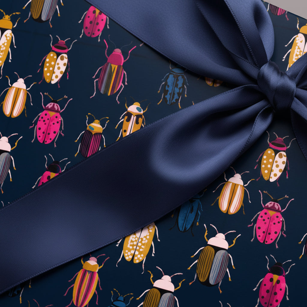 Navy blue gift box wrapped in colorful beetle-patterned paper, adorned with a satin ribbon bow.